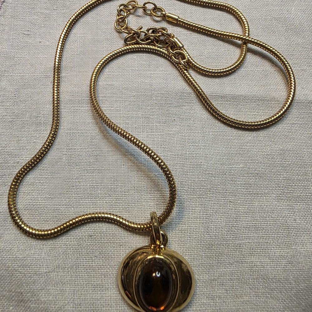 Vintage MonetElegant gold-tone pendant necklace featuring a warm amber cabochon